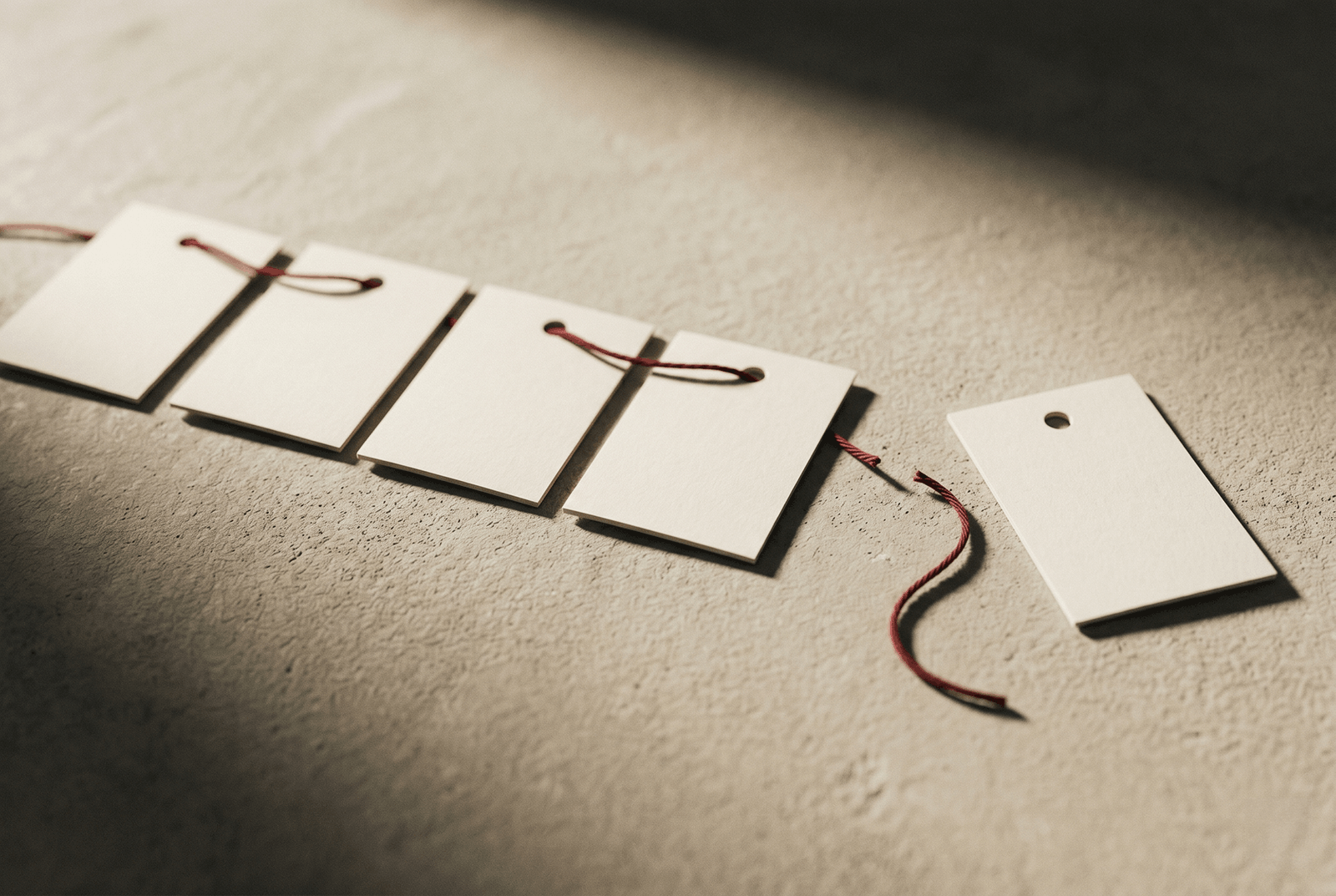 A series of tags connected by a thread, one disconnected